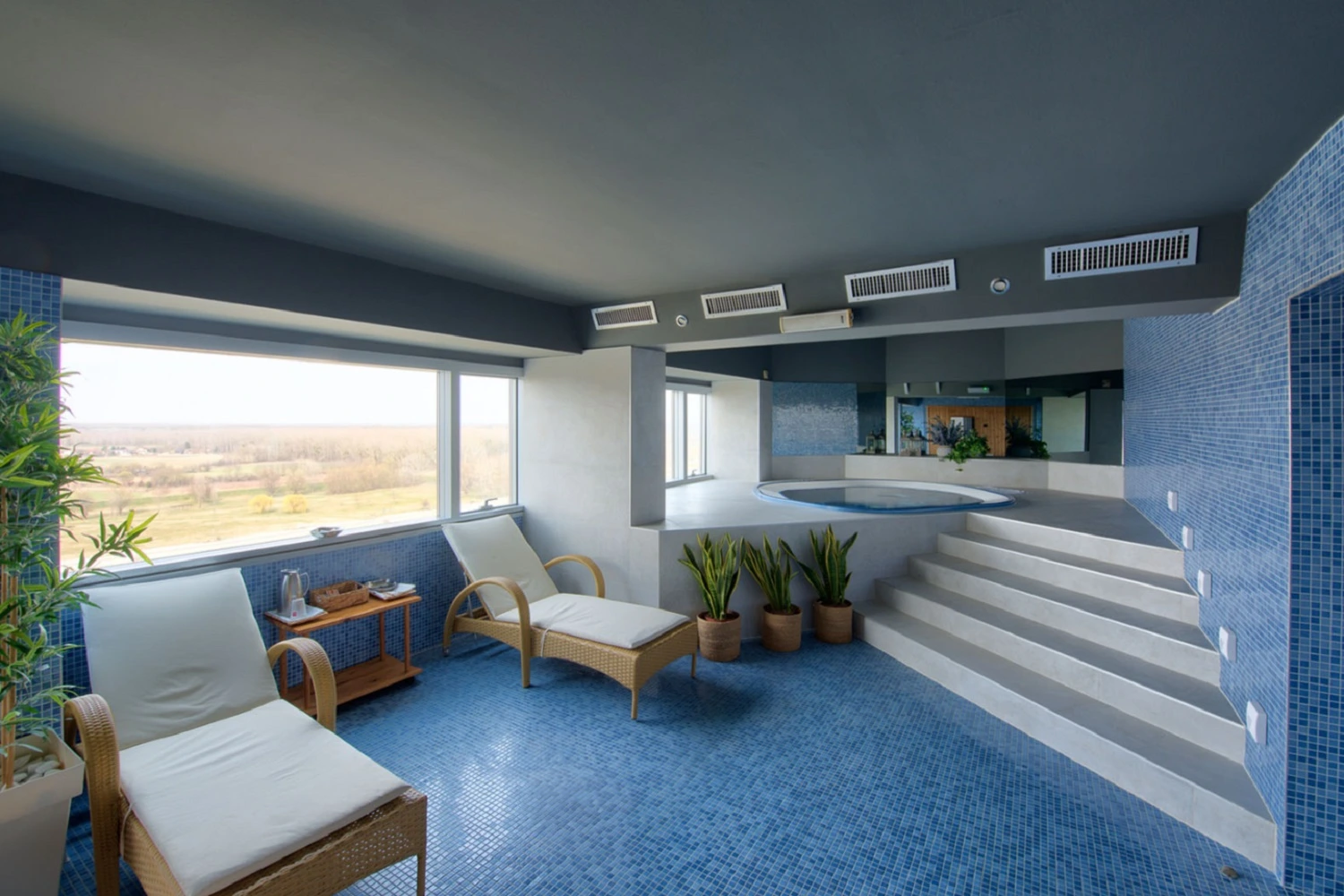 Strefa relaksu w hotelu od Marazzi z widokiem na roślinny krajobraz